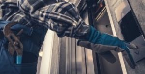 A technician pressing an elevator button